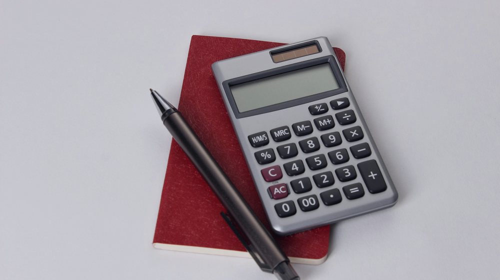 Una calculadora y una lapicera sobre un cuaderno