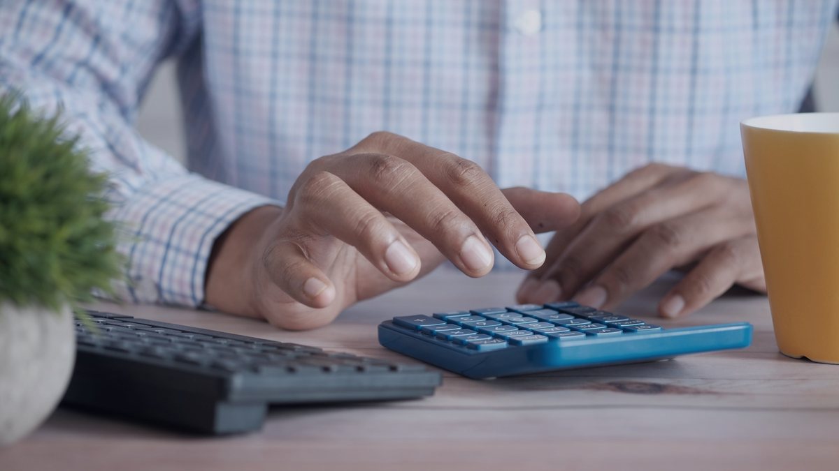 Manos usando una calculadora junto a un teclado